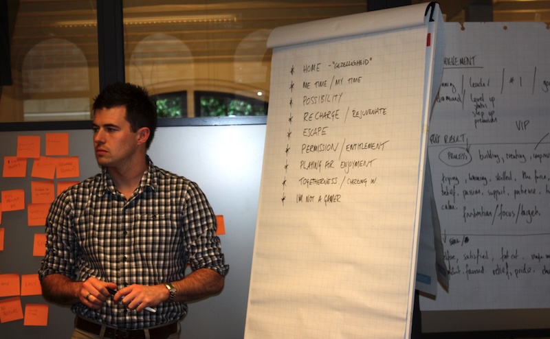 Christopher leading a brand workshop with notes on the board and orange post-its