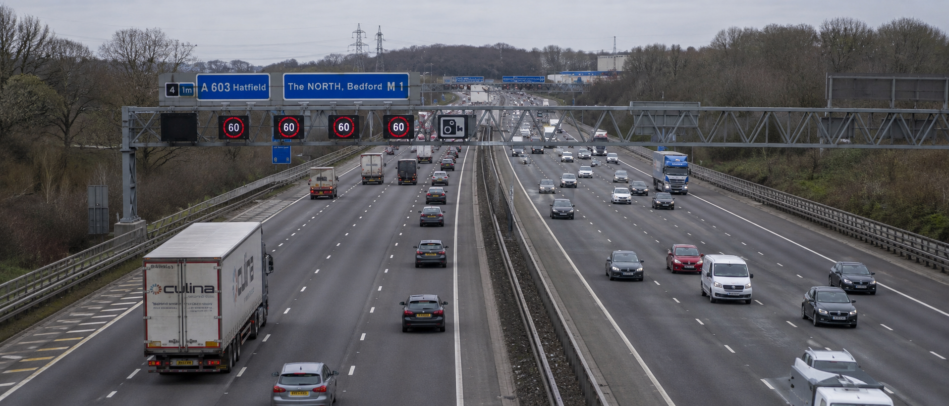 A British motorway viewed from a gantry, multiple lanes of traffic
